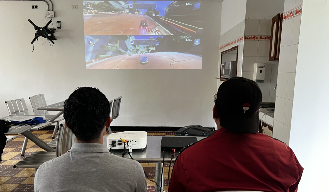 Dos colaboradores participando en la competencia de videojuegos.