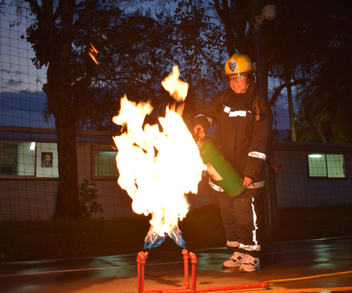 Mujer apagando fuego con extintor