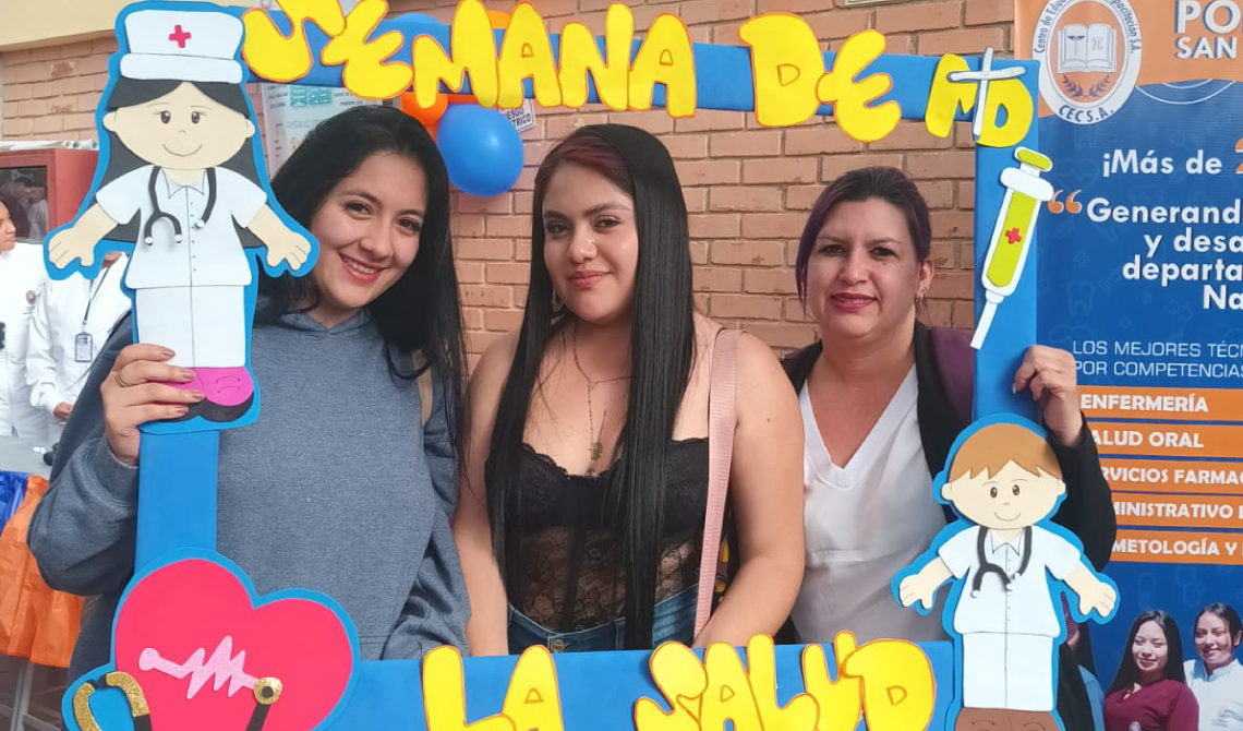 Tres mujeres con un marco para foto de la semana de la salud