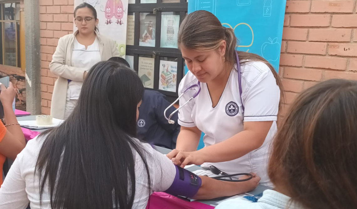 Enfermera tomando la tensión de una joven mujer