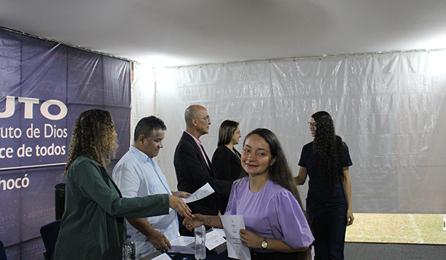 Estudiantes recibiendo su certificado de beca en el escenario