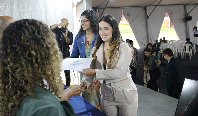 Estudiantes recibiendo su certificado de beca en el escenario