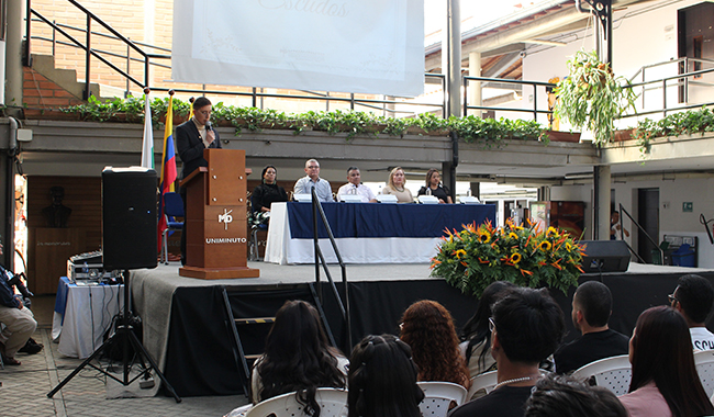 Estudiantes escuchando las palabras del presentador de ceremonia. 