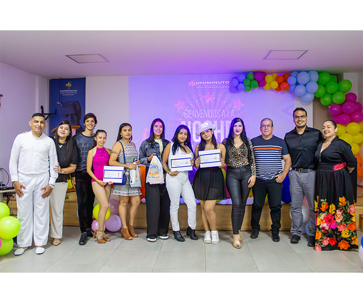 Participantes y jurado de la Noche de Talentos en el Centro Universitario Cúcuta Imagen grupal de los participantes y jurado de la Noche de Talentos en el Centro Universitario Cúcuta, realizada durante la Semana UNIMINUTO 2024. Se observa a los estudiantes que participaron en las categorías de canto y baile, junto con los miembros del jurado. El evento estuvo decorado con globos de colores, creando un ambiente festivo y alegre.