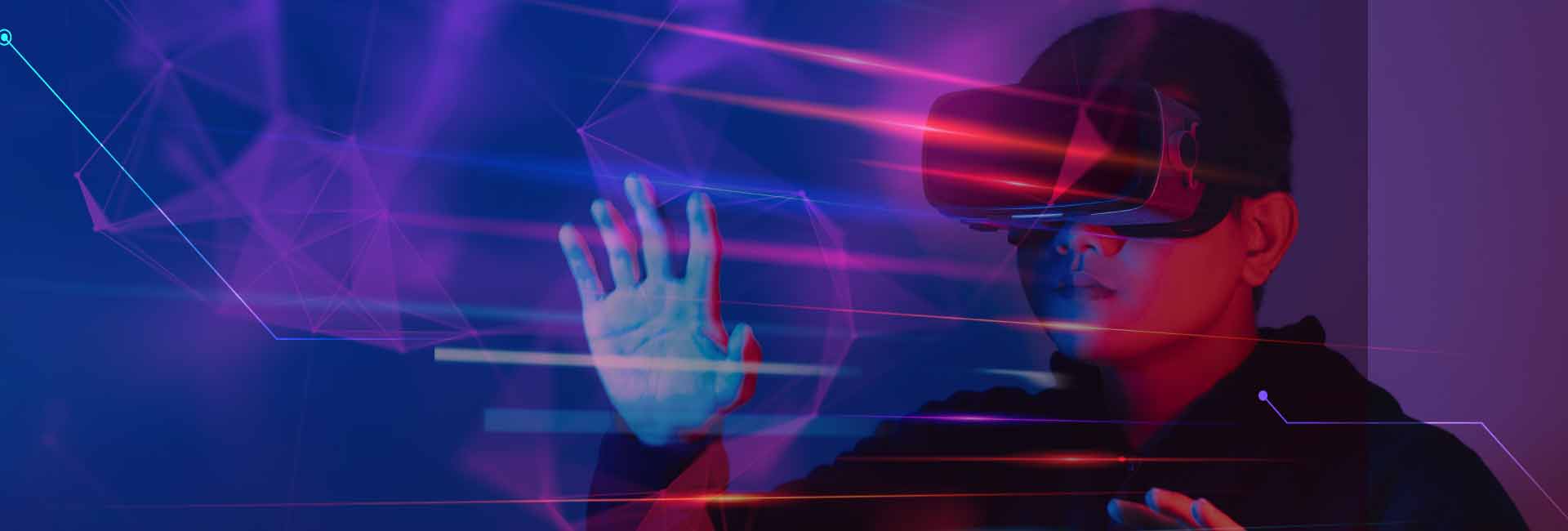 Un joven con visor de realidad virtual extiende las manos, interactuando con un entorno digital. Luces brillantes en tonos azules, rojos y morados atraviesan la imagen, creando un ambiente futurista e inmersivo.