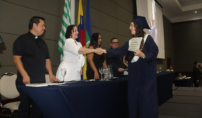 Vicerrectora Administrativa y Financiera felicitando a graduanda 
