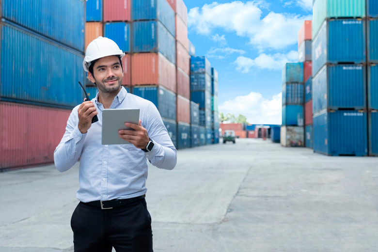 Hombre entre conteiners y con casco