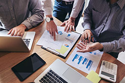 manos unidas junto a computador portátil