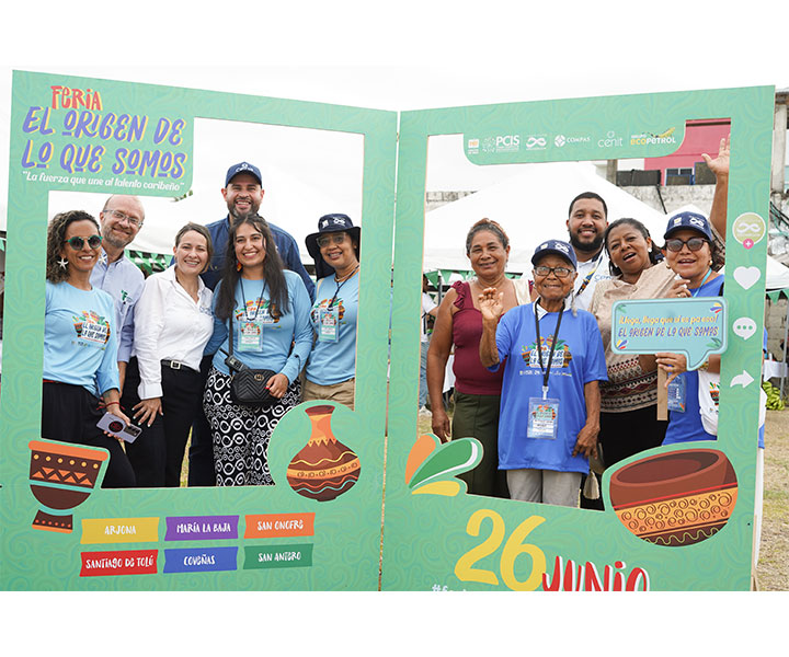 Hombres y mujeres emprendedores del Golfo de Morrosquillo posan en un gran marco decorativo en la playa de Coveñas, Sucre.