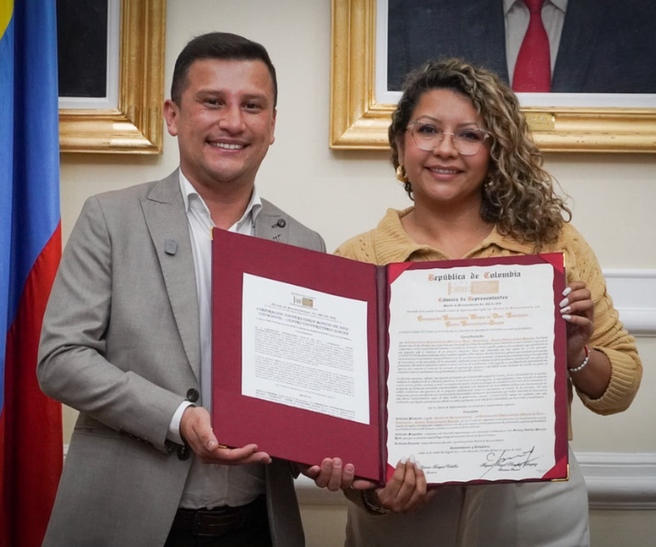El doctor Víctor Hugo Londoño Aguirre, rector de la Sede UNIMINUTO Cundinamarca-Boyacá, y la Dra. Francy Natalia Moreno Rincón, representante a la Cámara por Cundinamarca, posan junto a la Moción de Reconocimiento otorgada por la Cámara de Representantes a UNIMINUTO Centro Universitario Soacha, en el marco de sus 25 años de compromiso con la educación superior, la transformación social y el desarrollo de la región. 25 años  Transformación social Moción de reconocimiento Historia