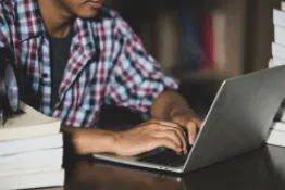 Foto recortada de joven mirando la pantalla de un portátil
