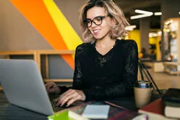 Mujer sentada en un escritorio escribiendo en el computador