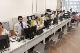 Personas trabajando en oficina frente a computadores