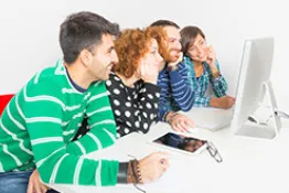 grupo de jóvenes muy alegres, sentados frente a un computador 