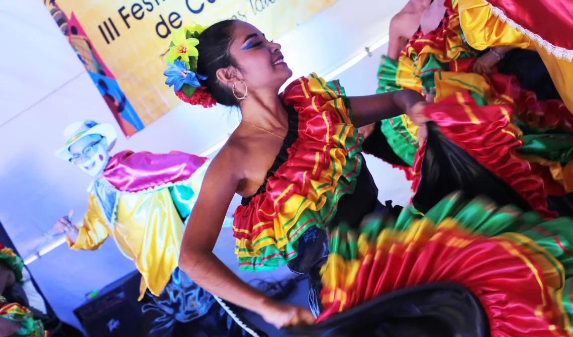 Mujer bonita de colorido vestuario, en medio del baile, ondeando su falda.  