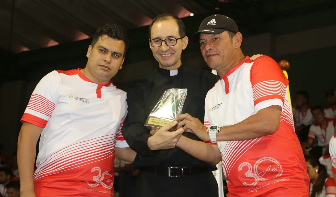 Padre Salomón Bravo entregando premio en los Juegos Nacionales UNIMINUTO 2022