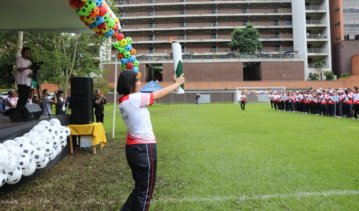 Estudiante de UNIMINUTO con la llama olímpica