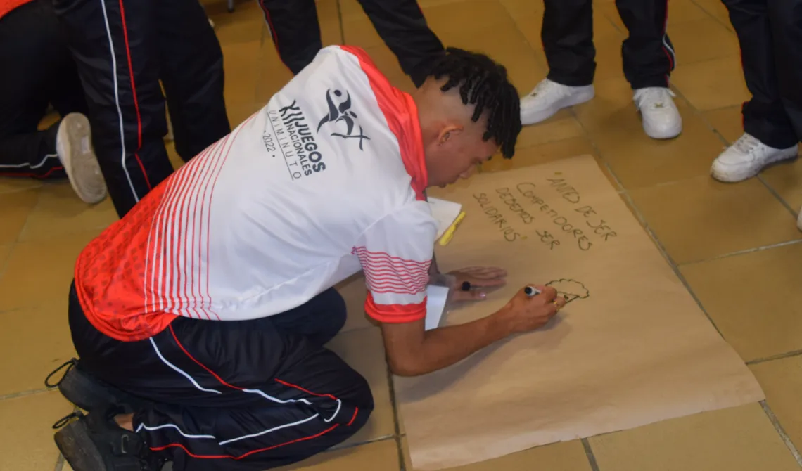 Estudiante escribiendo sobre una cartelera