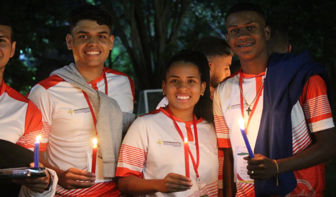 Estudiantes alegres con una vela en sus manos