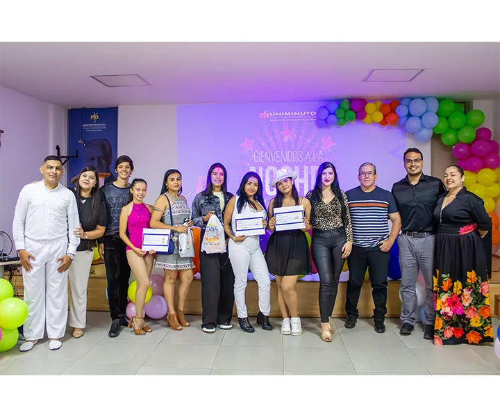 Imagen grupal de los participantes y jurado de la Noche de Talentos en el Centro Universitario Cúcuta, realizada durante la Semana UNIMINUTO 2024. Se observa a los estudiantes que participaron en las categorías de canto y baile, junto con los miembros del jurado. El evento estuvo decorado con globos de colores, creando un ambiente festivo y alegre.
