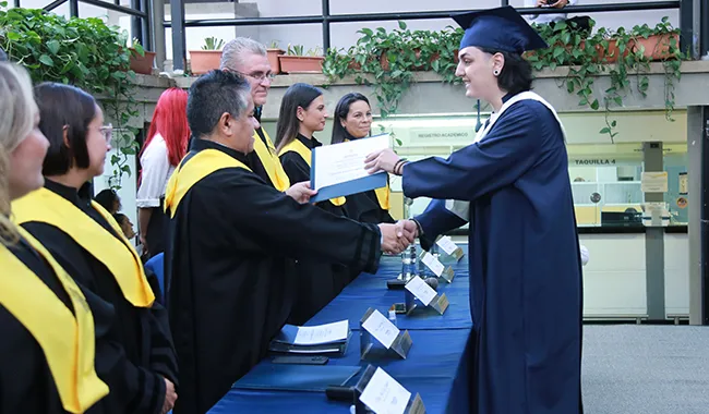Rector de UNIMINUTO Seccional Antioquia - Chocó entregando certificados a los estudiantes.