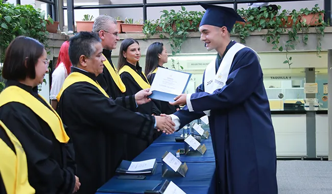 Rector de UNIMINUTO Seccional Antioquia - Chocó entregando certificados a los estudiantes.