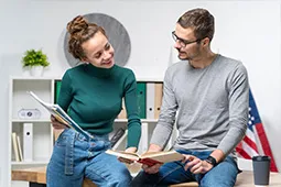 mujer con unas hojas y un hombre con un libro