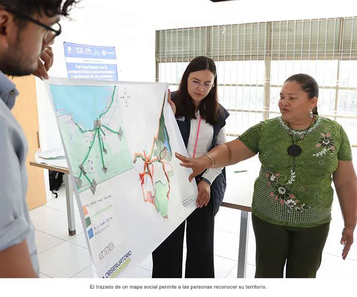 Mujer participa exponiendo al tallerista la cartografía social de su territorio 