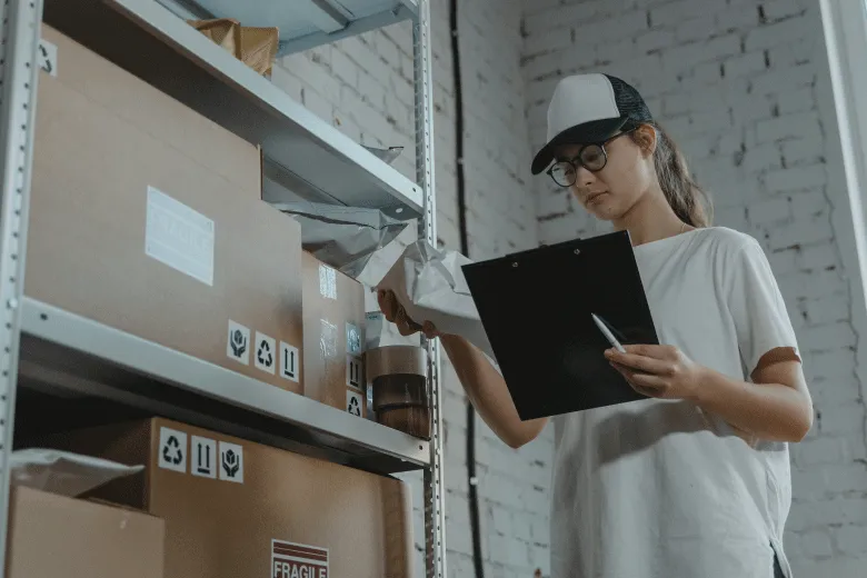 Mujer junto a cajas y una tabla de registros