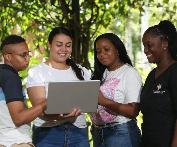 Estudiantes felices revisando un computador
