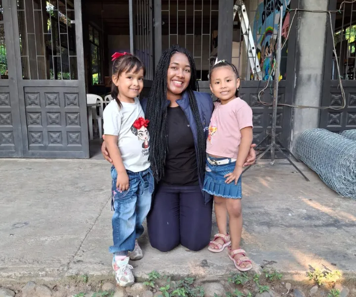 Estudiante de UNIMINUTO comparte con dos niñas en una comunidad rural durante una jornada de inmersión social, fortaleciendo el aprendizaje y el trabajo comunitario en el territorio.