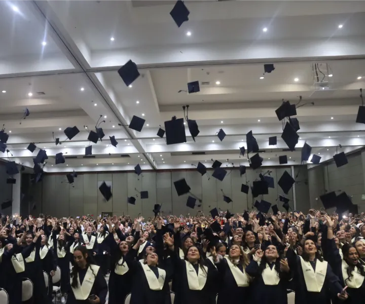 Graduados uniminuto lanzando birrete de grados 