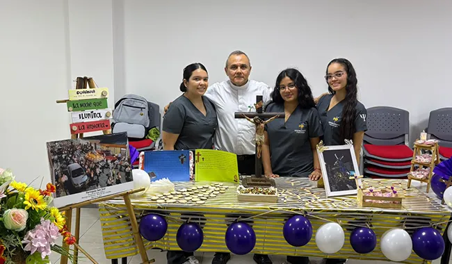 Grupo de personas detrás de una mesa con decoración temática y elementos simbólicos de Semana Santa.