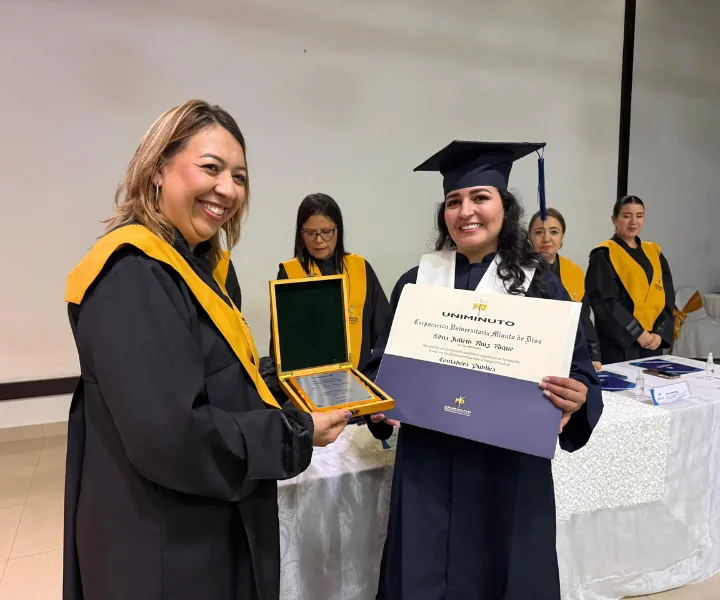 Egresada reconocida como la estudiante número 10.000 del Centro Universitario Ibagué de UNIMINUTO posa junto a la rectora Carolina Tovar Torres,durante la ceremonia de reconocimiento institucional por este hito académico