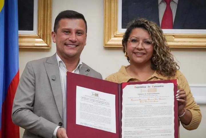 El doctor Víctor Hugo Londoño Aguirre, rector de la Sede UNIMINUTO Cundinamarca-Boyacá, y la Dra. Francy Natalia Moreno Rincón, representante a la Cámara por Cundinamarca, posan junto a la Moción de Reconocimiento otorgada por la Cámara de Representantes a UNIMINUTO Centro Universitario Soacha, en el marco de sus 25 años de compromiso con la educación superior, la transformación social y el desarrollo de la región. 25 años  Transformación social Moción de reconocimiento Historia