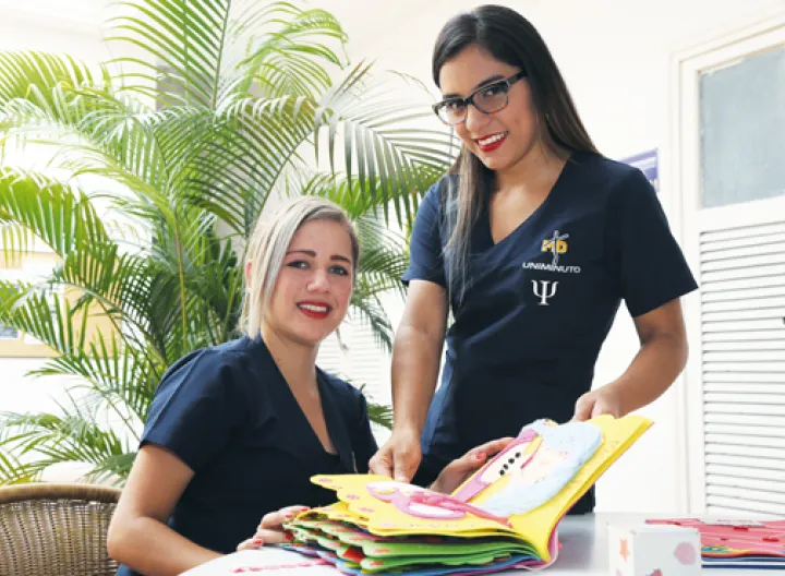 Dos estudiantes de psicología sonriendo frente a la Cámara