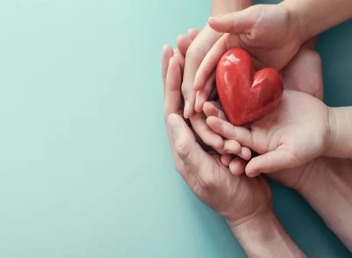 manos tomando una figura de corazón