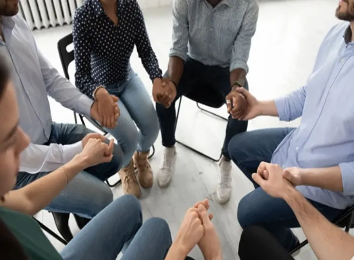 grupo de personas en círculo tomándose de las manos