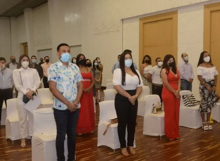 Varios personas de pie en un auditorio 