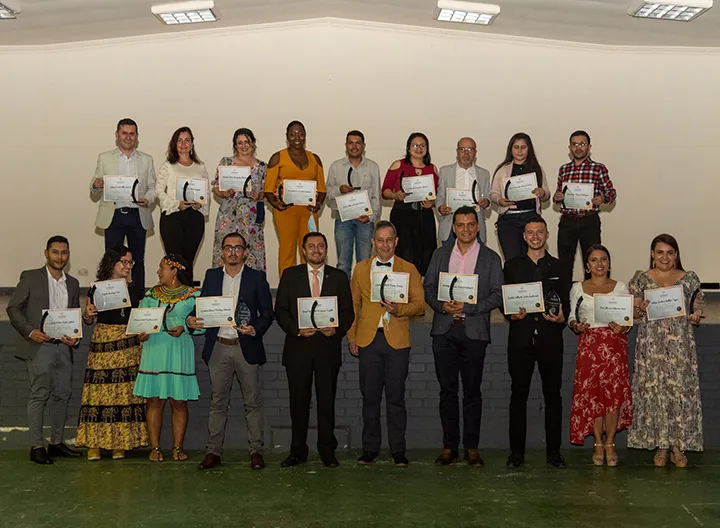Grupo de personas recibiendo estatuillas como reconocimiento