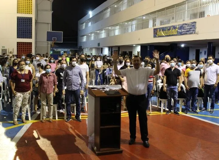Un hombre dictando una conferencias a muchas personas 