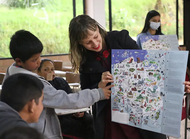 Sylwia  Wlodyga , voluntaria extranjera explica a los niños y niñas de la parroquia Jesús Obrero sobre la georreferenciación de Polonia. 
