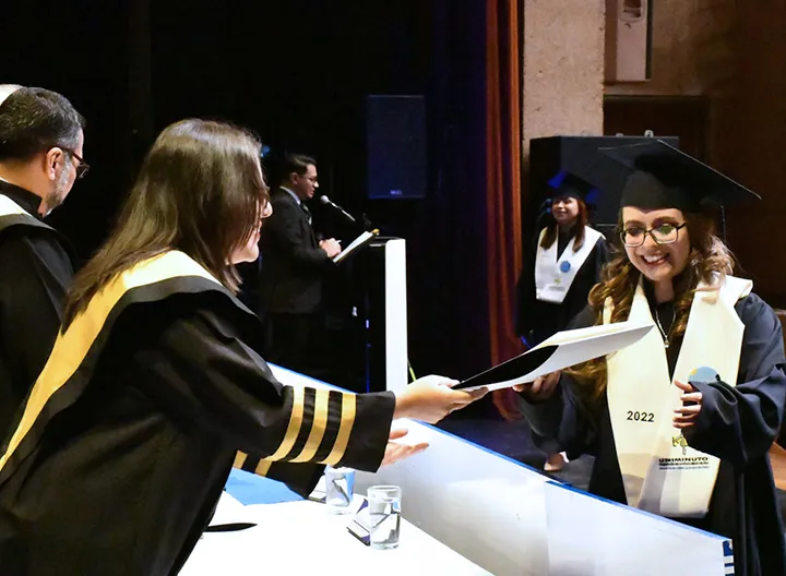 Estudiante recibiendo título de grados