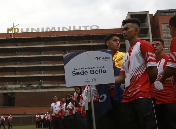 Deportista de UNIMINUTO sosteniendo la insignia de su delegación