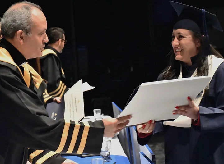 Estudiante recibeindo diploma de grado