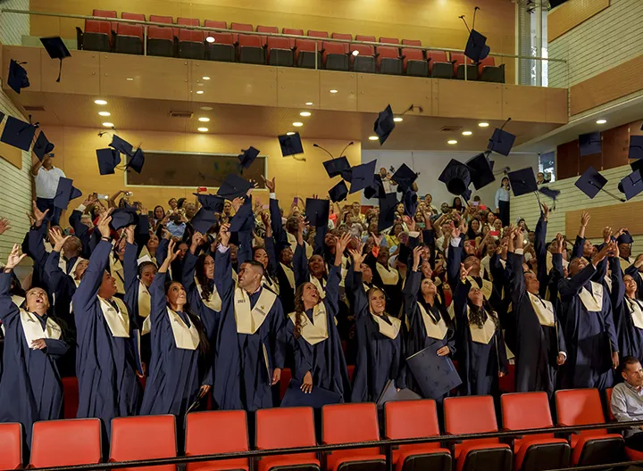 Graduandos lanzando el birrete 