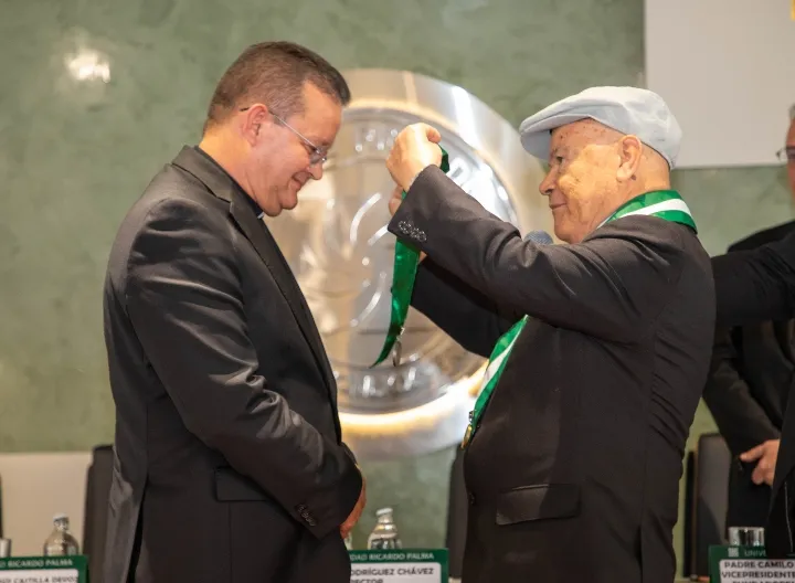 padre harold castilla recibiendo medalla