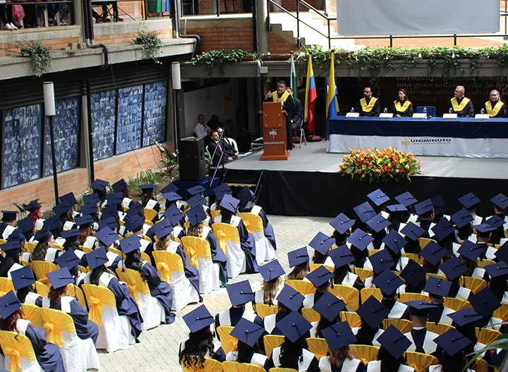 Graduandos con toga y birrete en ceremonia de graduación de UNIMINUTO seccional Antioquia - Chocó.