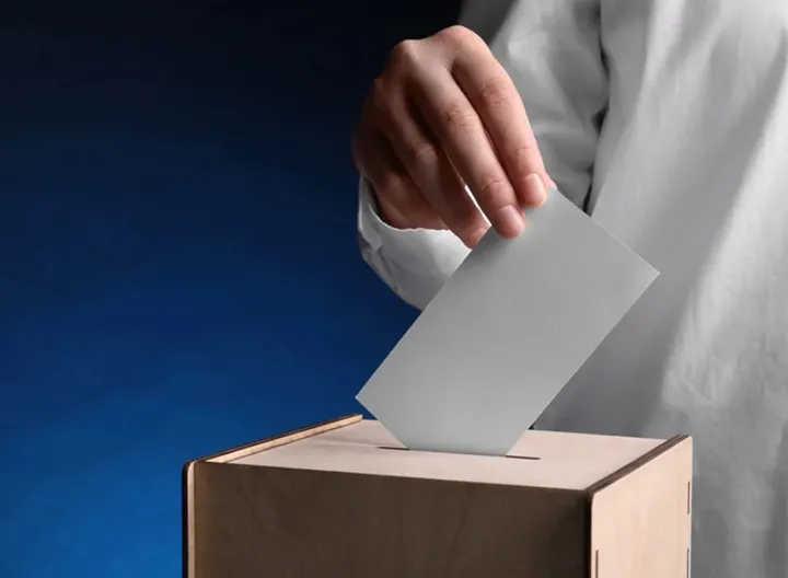 mano ingresando el voto en la urna en jornada electoral