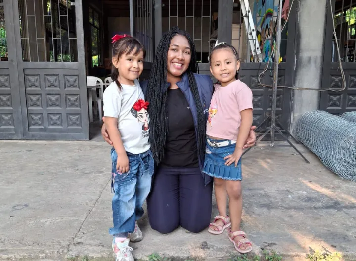 Estudiante de UNIMINUTO comparte con dos niñas en una comunidad rural durante una jornada de inmersión social, fortaleciendo el aprendizaje y el trabajo comunitario en el territorio.